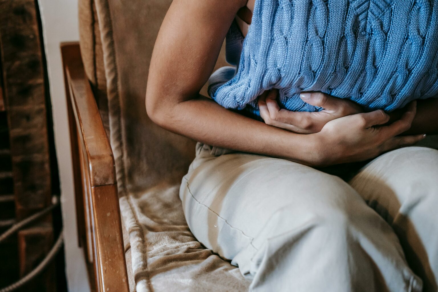 Femme assise qui se tient le ventre de douleur